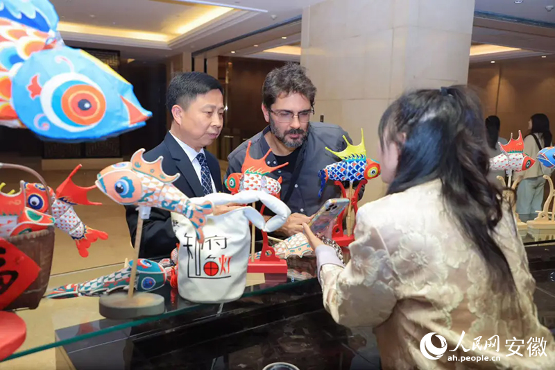 巴西旅行商米內(nèi)維諾·奧爾蒂斯·內(nèi)托·西爾維里奧（中）對(duì)魚(yú)燈充滿(mǎn)好奇。人民網(wǎng)記者 王曉飛攝